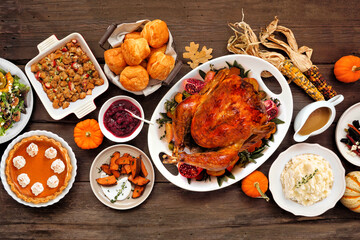 Thanksgiving turkey dinner. Top down view table scene on a rustic wood background. Turkey, mashed potatoes, stuffing, pumpkin pie and sides.
