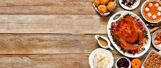 Thanksgiving turkey dinner. Above view side border on a rustic wood table banner background....