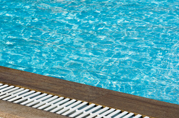 Fototapeta premium Water in swimming pool rippled water detail background. Blue in the water in the swimming pool.