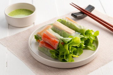 Vegetable Salad Rolls with Crab stick and Vietnamese Sausage in white plate,with seafood sauce dipping.