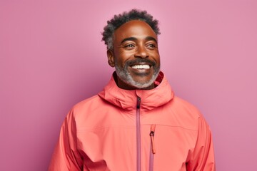 Obraz premium Portrait of a glad afro-american man in his 40s wearing a windproof softshell isolated in solid pastel color wall
