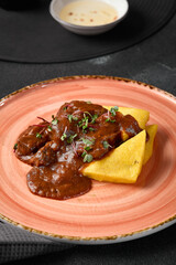 Rustic Polenta with Beef Cheeks Gourmet Dish on Pink Plate with Warm Lighting and Artistic Presentation