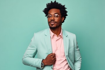 Portrait of a blissful afro-american man in his 20s dressed in a stylish blazer isolated on solid pastel color wall