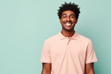 Obraz premium Portrait of a cheerful afro-american man in his 20s wearing a breathable golf polo in front of solid pastel color wall
