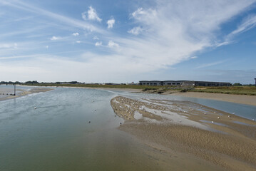 River Adur at Shoreham, Sussex, England. Mud at low tide. Buildings at Brighton Airport on right.