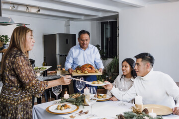 Mexican family having Christmas dinner and making wine toast at home in Mexico Latin America, hispanic teenagers daughter, son, mother and father