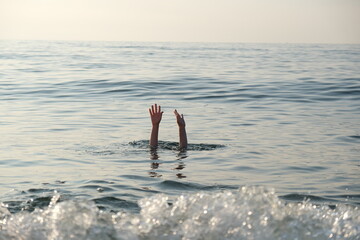 Hands of a drowning human above water. Drowning man in the sea