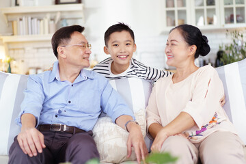 Fototapeta premium Asian family with father, mother, and son staying in living room together.