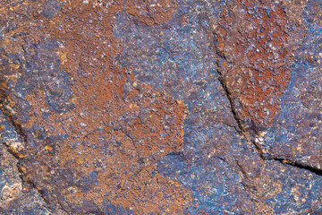 Texture of brown natural stone reminiscent of rusty metal.