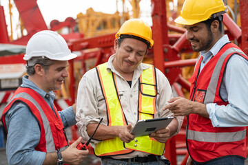 Happy Asia engineer man worker use tablet computer with team and spare crane background	