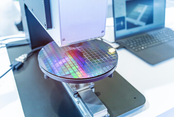 Silicon wafer with semiconductor microchip on machine process examining testing in microscope.