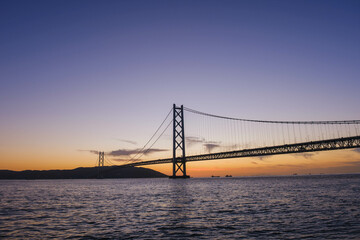 Obraz premium [HYOGO]Sunset view of Akashi Kaikyo Bridge, known as one of the world's largest suspension bridges, The faint orange sunset sky is beautiful, Azur Maiko, Japan