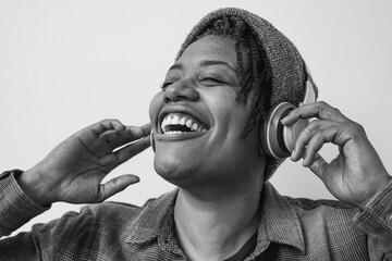 Hipster african american woman listening music with wireless headphone outdoor - Technology and...