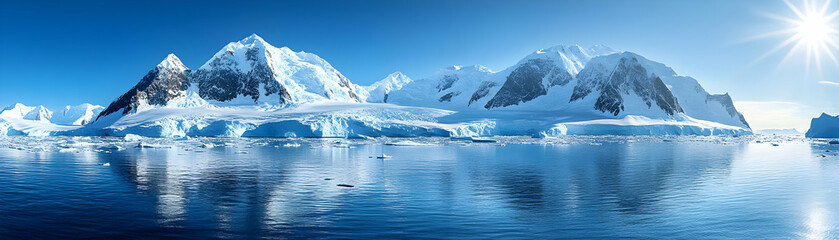 Snowy Mountains Reflect in the Still Blue Water with Sun Shining Brightly