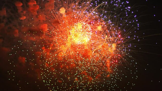 Golden blue green sparks scattering fireworks on the black night sky. General plan