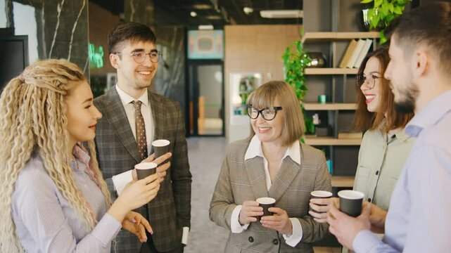 A diverse group of businessmen with an older female director, enjoy coffee during their lunch break, lively engage in conversation, sharing ideas and building connections in a relaxed setting.