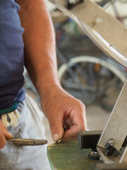 Mechanic cleaning a tiny part with a wire brush in a workshop