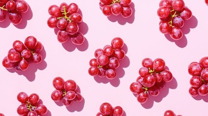 Red grapes arranged on a soft pink backdrop viewed from above