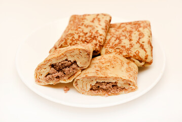 Pancakes with meat on a white plate. Pancakes with filling.