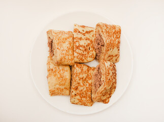 Pancakes with meat on a white plate. Pancakes with filling.