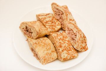 Pancakes with meat on a white plate. Pancakes with filling.