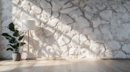 A minimalist scene featuring a stone wall, a floor lamp with a white shade on a wooden tripod stand, and a potted plant, showered with gentle daylight.
