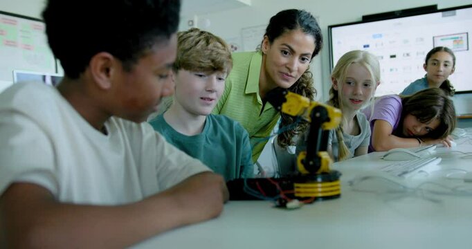 School Children in STEM Computer Classroom, Looking at Robot arm with Teacher