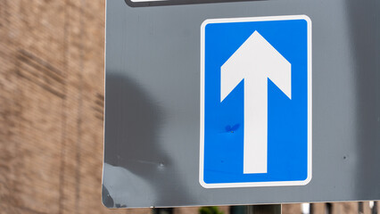 Blue One-Way Traffic Sign with Urban Building Background