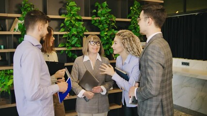 In a vibrant and modern office space, a diverse group of professionals is deeply engaged in a collaborative and dynamic discussion, sharing ideas