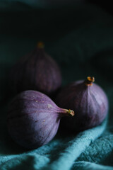 Close up of fresh ripe fig fruits in green fabric with dark shadows