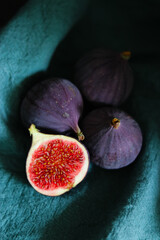 Close up of fresh ripe fig fruits in green fabric with dark shadows