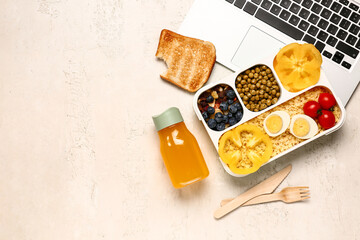 Laptop, bottle of juice and lunchbox with tasty food on white background