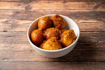 Caption: Tasty Caribbean food served on a white plate or white bowl on a rustic vintage wooden table backdrop - colorful home cooked meals and desserts with chicken, chips, vegetables, rice, bbq, stew