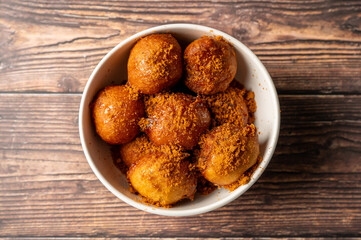 Caption: Tasty Caribbean food served on a white plate or white bowl on a rustic vintage wooden table backdrop - colorful home cooked meals and desserts with chicken, chips, vegetables, rice, bbq, stew