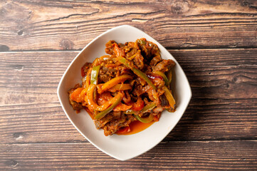 Caption: Tasty Caribbean food served on a white plate or white bowl on a rustic vintage wooden table backdrop - colorful home cooked meals and desserts with chicken, chips, vegetables, rice, bbq, stew