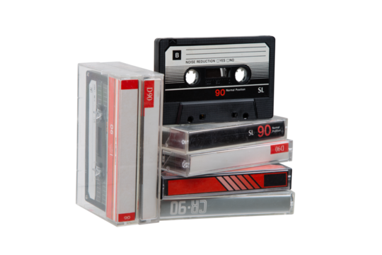 A stack of audio cassettes. Close-up of an audio cassette with a sticker without text.  Cassettes for audio recordings and music. Analog storage medium.