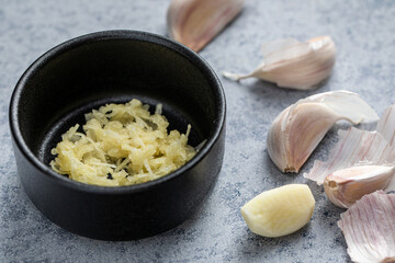 Freshly Grated Garlic with Cloves on a Kitchen Counter