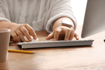 Female programmer typing on computer keyboard at her workplace in office, closeup