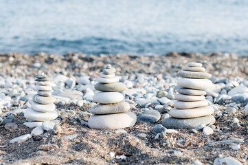 Stacking the equalizer stone on the blue beach with lots of pebbles around