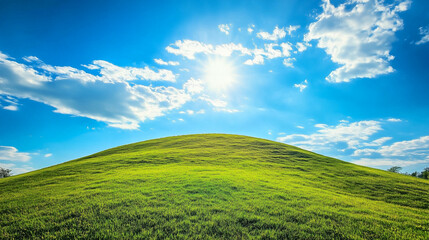 Obraz premium Sunny green field with bright blue sky and clouds