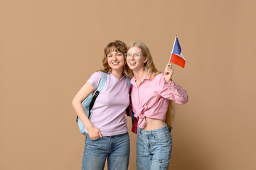 Female students with French flags on beige background