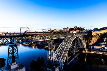 The metro trains is  crossing over the Luís I Bridge 