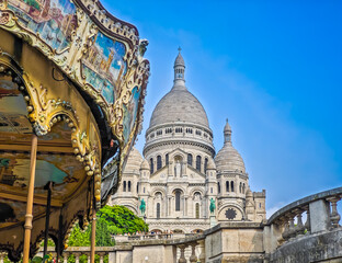 Fragment of colourful carousel with Basilique Du Sacre Coeur de Montmartre. Close up photo of Sacred heart iconic white-domed church in Paris, France © Audrius
