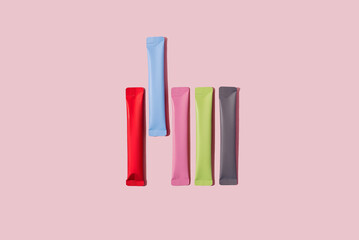 Colorful portion packs or stick packets on pastel pink background. System detox, energy booster or...