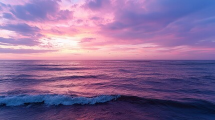 Fototapeta premium The ocean is calm and the sky is a beautiful shade of pink. The water is a deep blue color