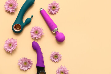 Composition with different vibrators and beautiful flowers on color background