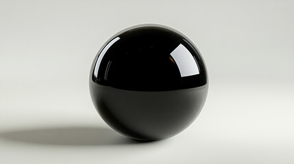 A smooth, glossy black sphere resting on a light-colored surface with subtle reflections