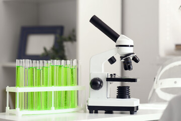Modern microscope and chemical flasks on table in teenager's room