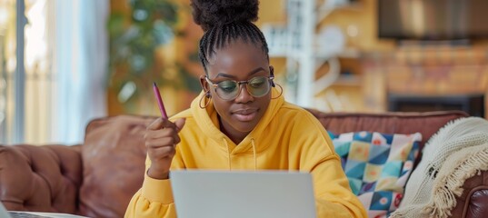 Woman taking notes during a webinar, using a laptop and notebook