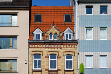 a pretty old small founder's era house made of yellow and red brick, squeezed into simple post-war buildings in Cologne Ehrenfeld